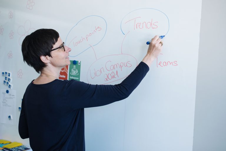 Caren Degen schreibt auf ein Whiteboard