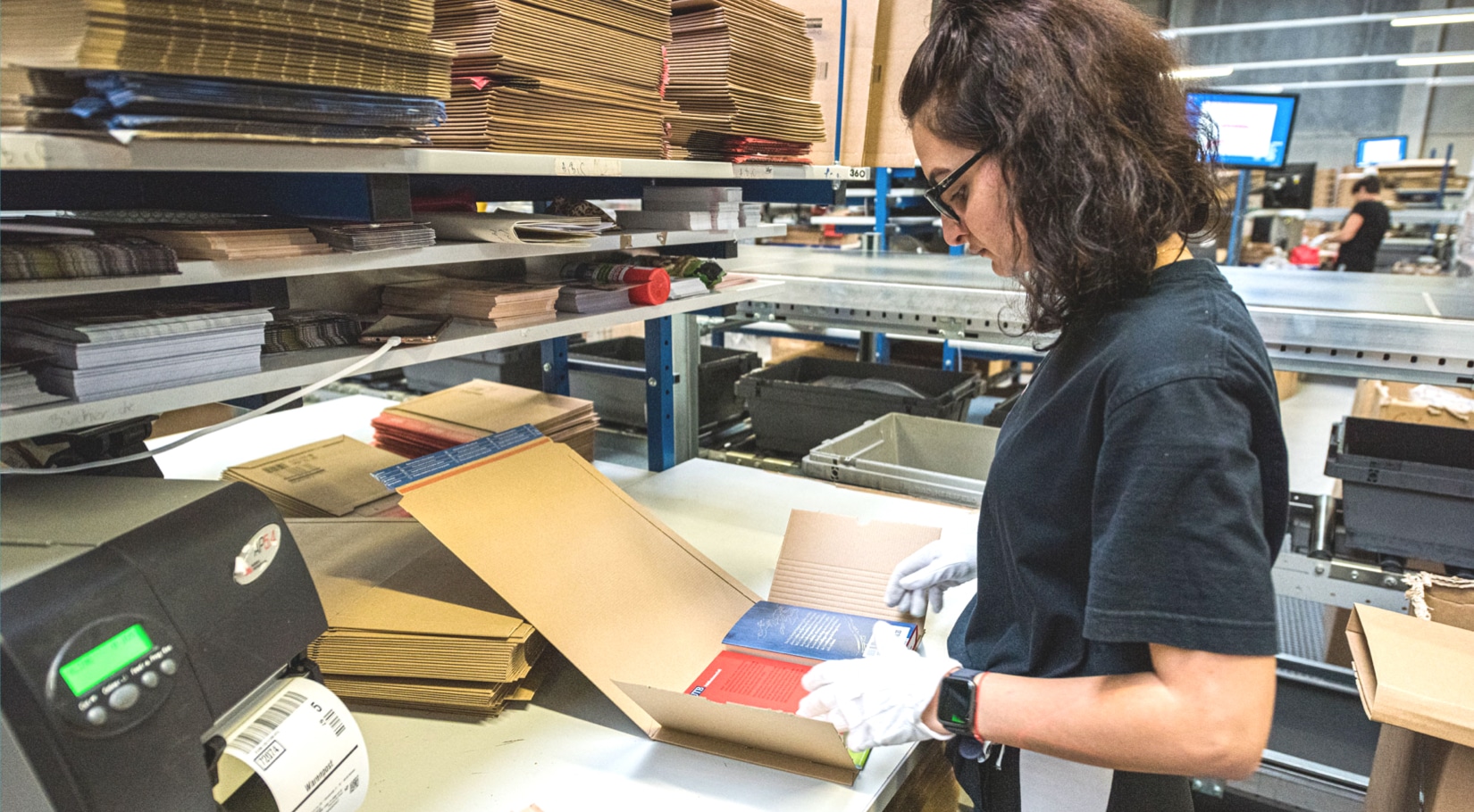 Libri Mitarbeiterin bereit im Versandservice eine Bestellung für den Versand vor im Logistikzentrum