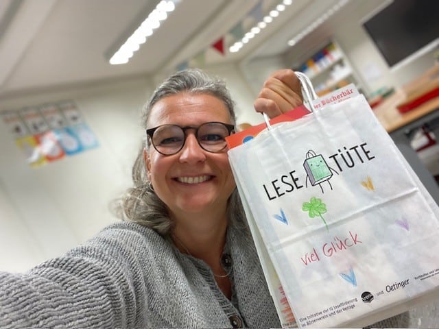 Buchhändlerin Julia Freund auf dem Weg zur Schulaula mit Lesetüte in der Hand.