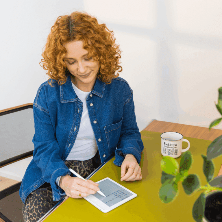 Junge Frau macht sich mit dem tolino stylus Notizen im tolino vision color Weiß.